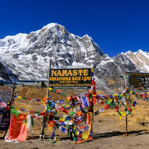 Trekkers on the trail below Annapurna South, with the base camp amphitheatre of peaks visible ahead